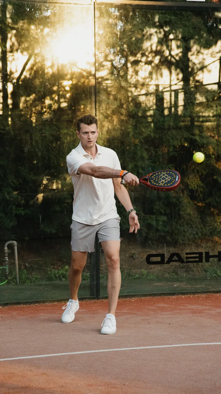 Padelspieler beim Schlag im Abendlicht